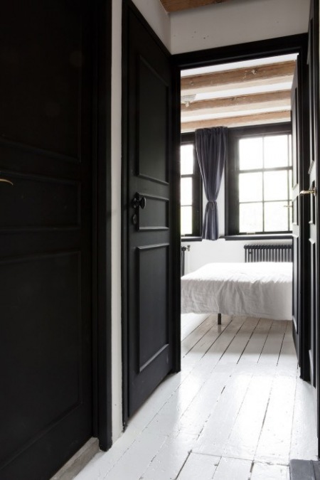 Białe deski i czarne drzwi w aranżacji sypialni