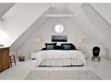 skandynawska sypialnia nie jest nudna - surowa ściana z białej cegły i biel podłogi zostały przełamane dekoracjami w...