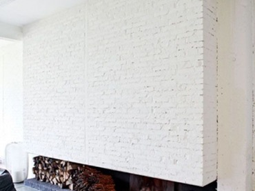 widowiskowa ściana z białej cegły, która zrazem jest częścią kominka w prostej, nowoczesnej formie