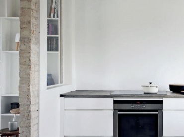 Minimalistyczna aranżacja białej kuchni z surową cegłą i betonową posadzką (21291)