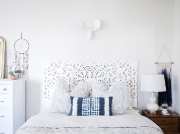 Dekoracyjne wezgłowie łóżka, a także inne delikatne białe dekoracje (głowa łosia na ścianie, wysoka komódka, lampa)...