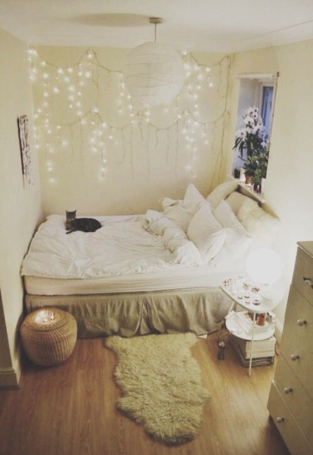 Mała sypialnia z dekorację girlandami świetlnymi