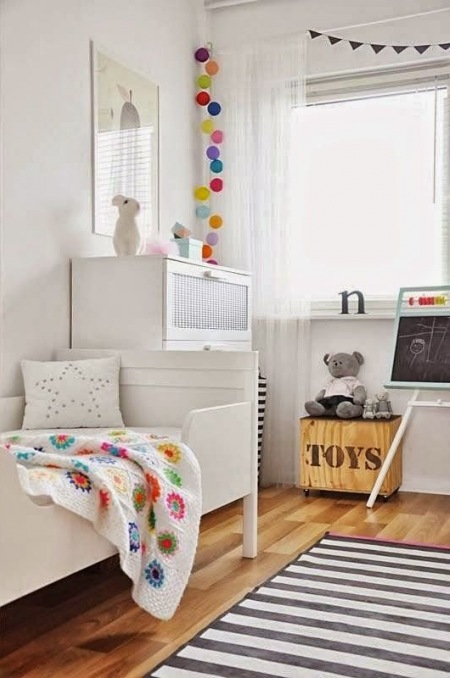 Skandynawski styl pokój dla dziecka,niebieskie pufy,pomarańczowe pufy i siedziska,typografie w pokoju dziecięcym,drabina z girlandą z kolorowych kul,kolorowe girlandy z bawełnianych kul w pokoju dziecięcym,cziecięce pokoje z girlandami,bawełn