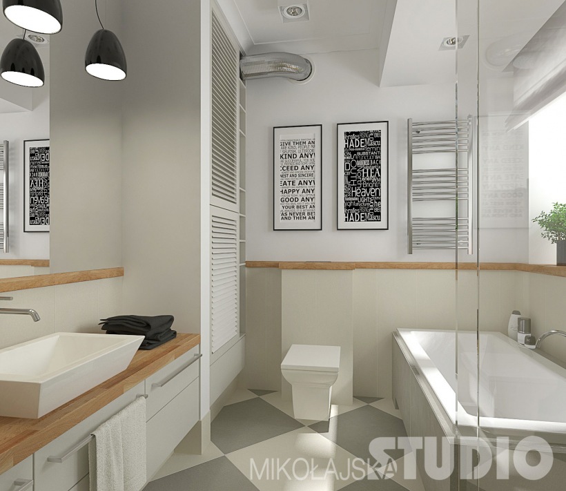 Biało-szara płytka gresowa ułożona w karo,szare szafki z drewnianym blatem i czarne wiszace lampy nad prostokatna umywalką,czarno-białe grafiki na ścianie w łazience