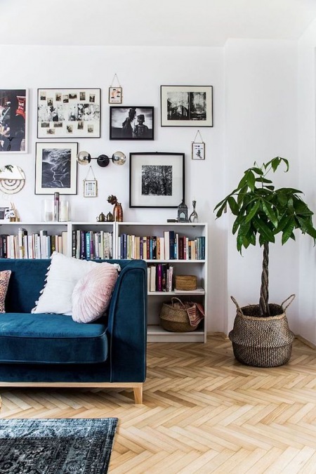 Granatowa sofa i mała biblioteczka w salonie