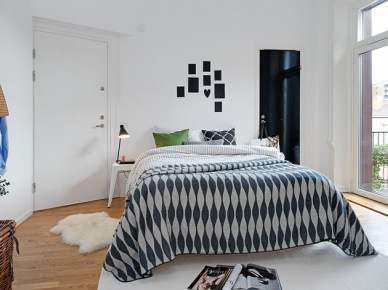 Aranżacja skandynawskiej sypialni z szaro-białą narzutą na łóżku (21916)