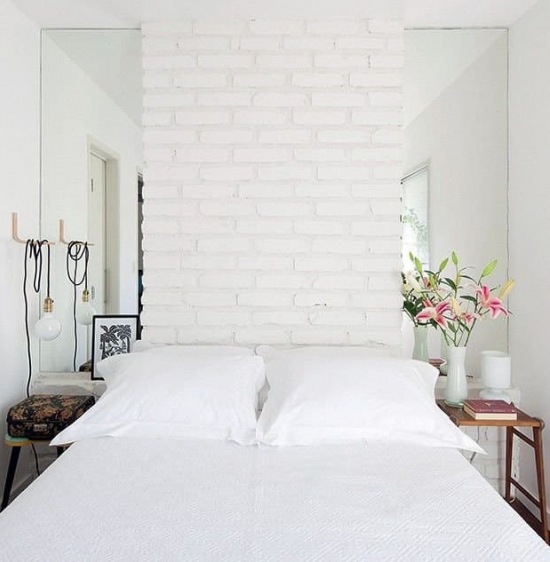 Ściana z białych cegieł w małej sypialni