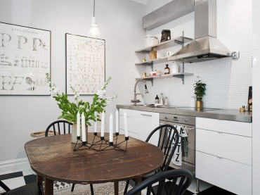 Biała kuchnia z betonowym blatem,czarne krzesła skandynawskie,owalny stół,typografie na ścianie w kuchni (28577)