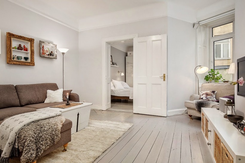 Biało-szary salon w stylu skandynawskim,drewniane deski na podłodze w salonie,szare ściany w salonie
