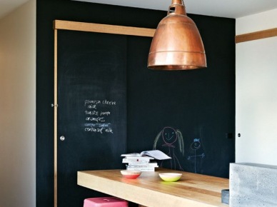 Różowe wysokie stołki przy drewnianej ladzie w kuchni z czarną ścianą z farby tablicowej (25296)