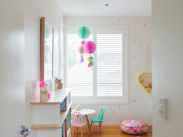 Dodatki w pastelowych kolorach: pompony, mebelki i puf wspaniale prezentują się na tle białych ścian i jasnej,...