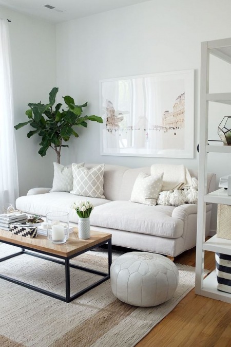 Mały salon z białą sofą i pastelowymi dodatkami