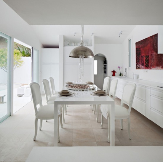 Klasyczne białe krzesła,nowoczesny stół i industrialna lampa w białej jadalni