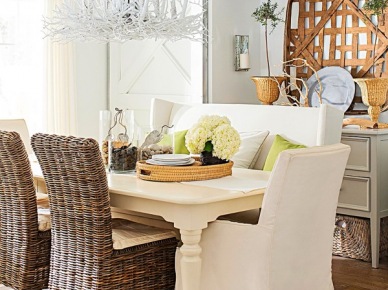 Biały żyrandol z korzeni i witek nad drewnianym białym stołem w jadalni z wiklinowymi krzesłami,białe ubranka na krzesła,dywan w szaro-białe paski,szare szafki i drewniane dekoracje na ścianie (26156)