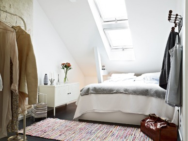 Skandynawska sypialnia na poddaszu z betonową ścianą i białymi belkami (23182)