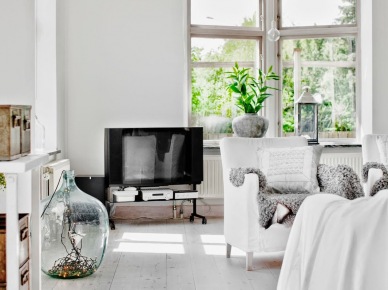 Biały salon w stylu skandynawskim z szafką na kólkach,ozdobnym słojem szklanym i białym fotelem (24632)