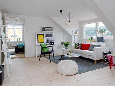 Białe klimatyczne wnętrze z kolorowymi dodatkami - aranżacja mieszkania na poddaszu w stylu skandynawskim