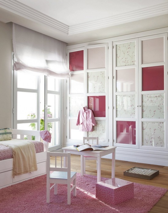 Biało-różowa aranżacja dziecięcego pokoju z zabudowaną szafą przy ścianie