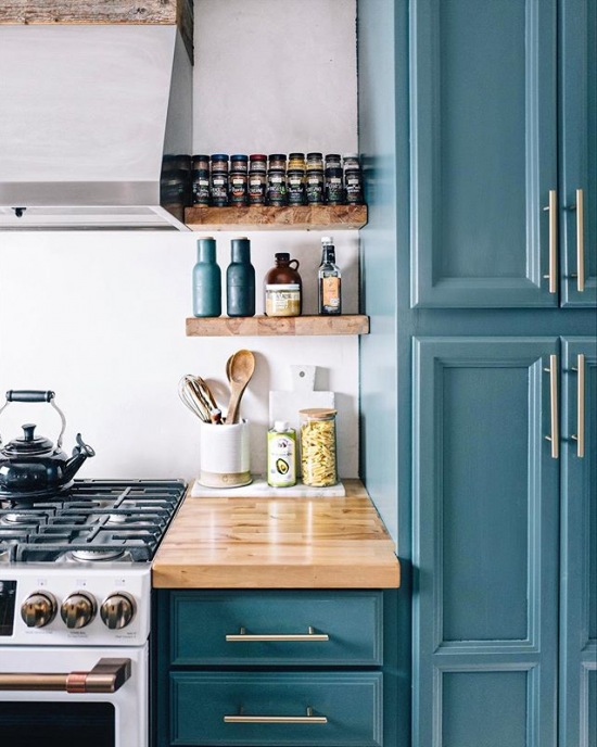 Drewniane blaty i półki w aranżacji niebieskiej kuchni