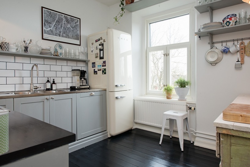 Czarna podloga,szare meble  i półki w aranżacji tradyjnej kuchni skandynawskiej