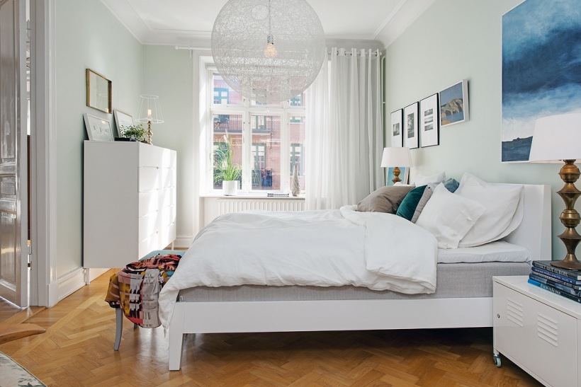Kulista transparentna lampa w bialym kolorze,galeria ilustracji i obrazów nad łóżkiem w białej sypialni w stylu skandynawskim
