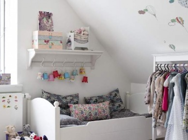 Dziergane dywaniki i drewniane łóżko w dziecięcym pokoju (21052)