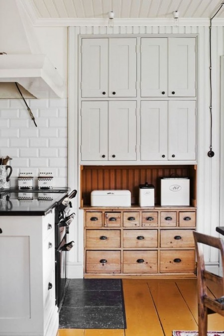 Białe i drewniane szafki do przechowywania w wysokiej kuchni