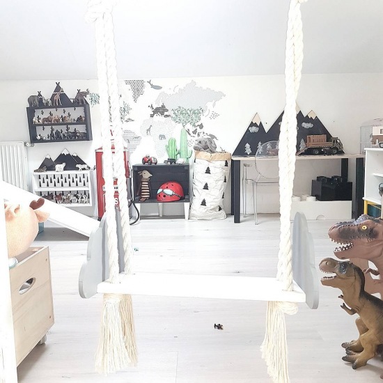Biała huśtawka i drewniana podłoga w pokoju dziecięcym