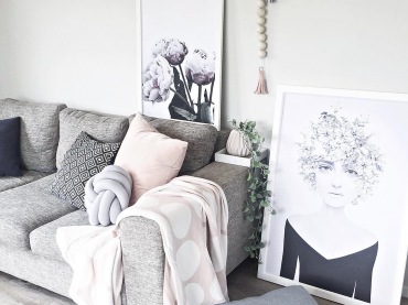 Grafiki w białych ramach stojące na podłodze i za sofą zdecydowanie dekorują salon. W pokoju dziennym jest przytulnie i ciepło, ale także...