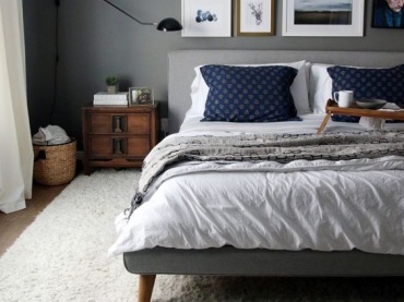Aranżacja sypialni z szarym łóżkiem i drewnianą szafą nocną (53217)