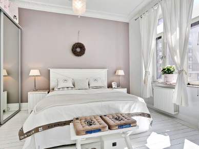 Białe drewniane łóżko,białe dekoracyjne zasłony i szara ściana w sypialni (24390)