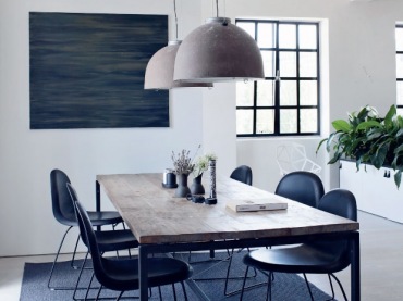 Dwie lampy nad prosty stołem świetnie dekorują jadalnię, a czarne krzesła dodają elegancji i smaku.