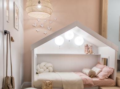 W pokoju dziecięcym znajduje się bardzo ciekawe oświetlenie. W łóżku, które przypomina domek, wiszą trzy lampy w kształcie baloników. To podkreśla przytulny charakter...