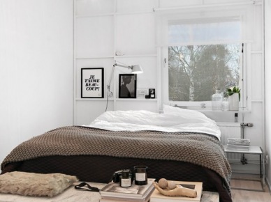 Żarówka na kablu,industrialne białe panele na ścianie,kamienna ławka ze szklanymi bokami i czarno-białe grafiki w skandynawskiej sypialni (27387)