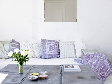 Industrialny stolik kawowy z metalu i biało-fioletowe poduszki na sofie w salonie (24023)