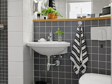 Czarne i białe kwadratowe płytki na scianie w małej łazience z drewnianymi półkami i szafkami (25904)