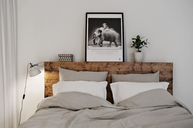Drewniane wezgłowie łóżka w szarej sypialni