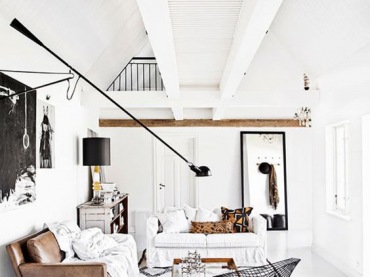 Drewno i biel stanowią klasyczny zestaw skandynawskiej aranżacji. Belki pod sufitem oraz skórzana sofa w znaczący...