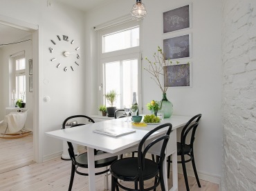 Ceglana ściana pomalowana na biało w jadalni z rozkładanym stołem i czarnymi krzesłami (22973)