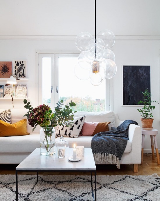 Biała sofa udekorowana kolorowymi poduszkami w salonie