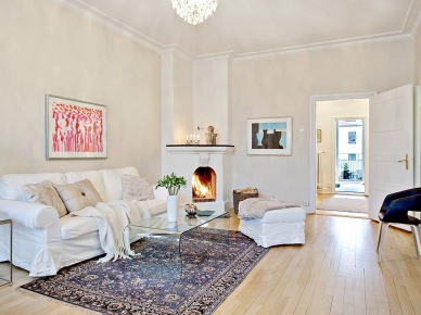 Aranżacja rozbielonego mieszkania w eleganckim stylu francuskim z kominkiem w salonie