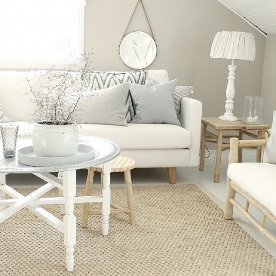 Okrągły stolik taca z marokańskimi wzorami,tkany dywan,biała sofa,okrągłe lustro wiszące,drewniany stołek i drewniana kanapa z białymi siedziskami
