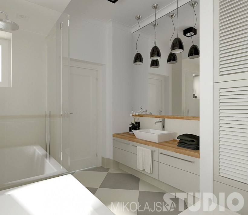 Ściana lustrzana nad szarymi szafkami z prostokatna uwmywalką,czarne lampy wiszące nad łazienkową umywalką,biało-szara posadzka ułożona w duże karo