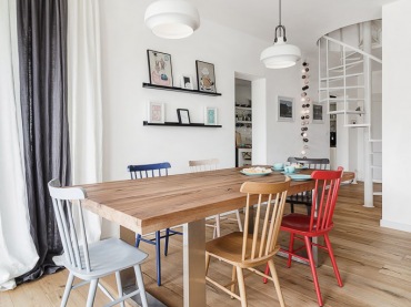 Prosta i funkcjonalna aranżacja jadalni, która idealnie wpisuje się w koncepcję aranżacji całego domu. Skandynawski styl podkreślony wyborem drewnianych mebli został lekko urozmaicony różnobarwnymi krzesłami przy pięknym stole. Delikatne ozdobny na wąskich półeczkach na ścianie w subtelny sposób dekorują...