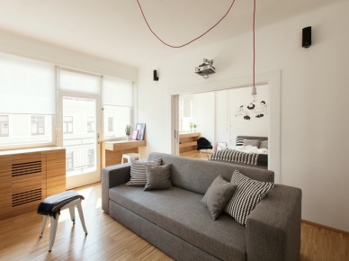 Szara sofa, drewniana zabudowa i różowe kable w salonie w stylu nowoczesnym (22278)