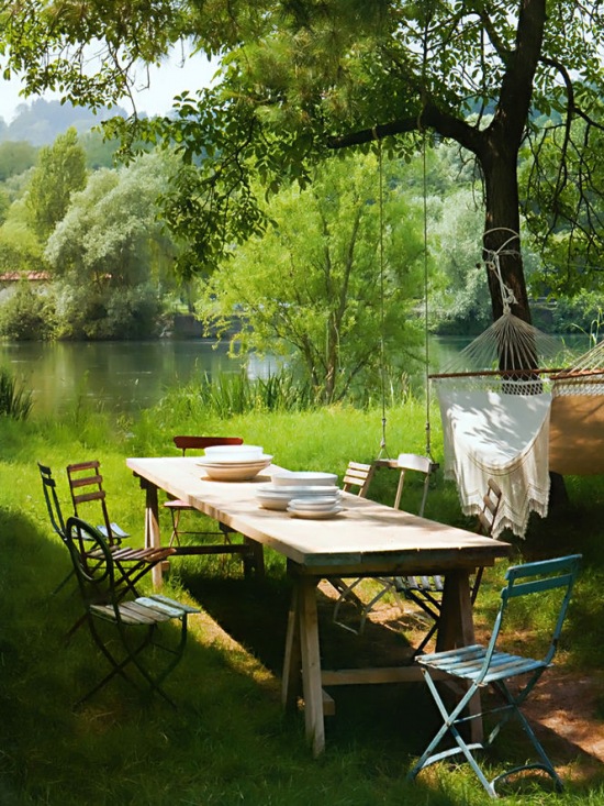 Ogrodowa jadalnia przy jeziorze z wiszącym hamakiem na drzewie