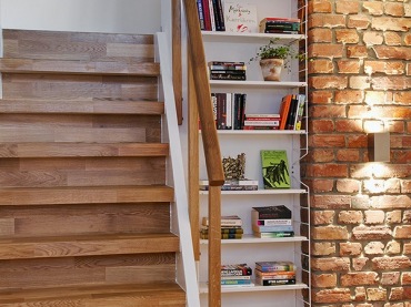 Drewniane brązowe schody i wnęka z książkami i cegłą, wszystko fajnie ze sobą współgra. Panuje tu klasyczny styl i...