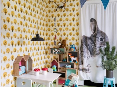 Miętowy kolor desek na podłodze w pokoju dziecięcym, z tapetą w żółto-czarne drzewka,niebieskimi proporczykami i zasłonami z królikami (27529)