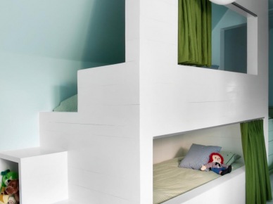 W pokoju dziecięcym w ciekawy sposób zorganizowano łóżka dla chłopców - to w zasadzie łóżko piętrowe w zabudowanej formie, które zachwyca swoją przytulnością. Zielone zasłonki pozwalają stworzyć jeszcze bardziej kameralny klimat podczas spania czy wypoczynku na...