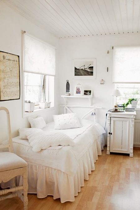 Biała szafka i łóżko w prowansalskiej aranżacji wiejskiej sypialni